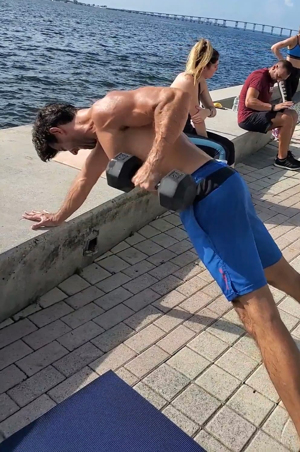 Vinny coaching a client through dumbbell rows on the Miami waterfront