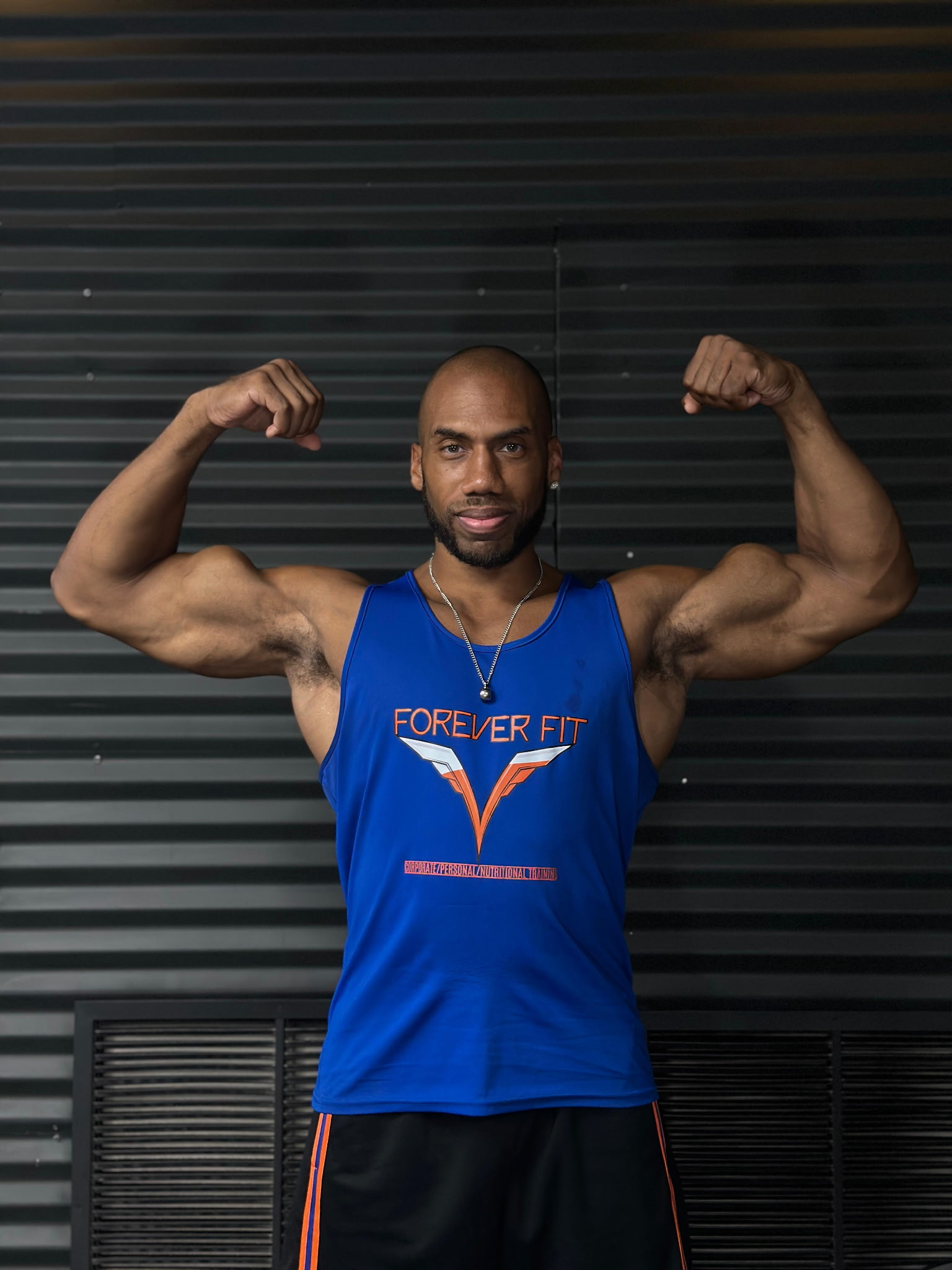 Vinny, Forever Fit coach, flexing and showing his physique